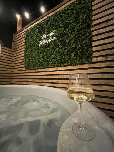 a glass of white wine sitting on a table at The Telephone exchange very quaint hot tub stay in Scarisbrick