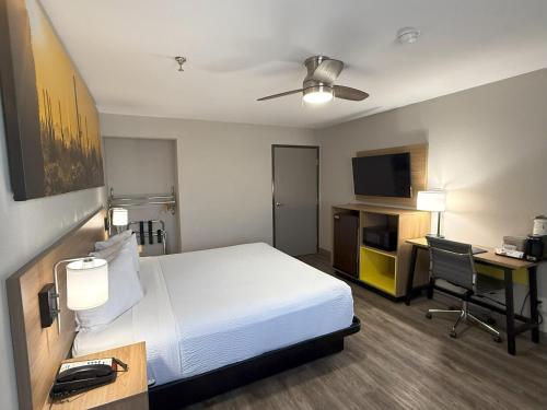 a hotel room with a bed and a desk with a computer at Days Inn by Wyndham Yuma in Yuma