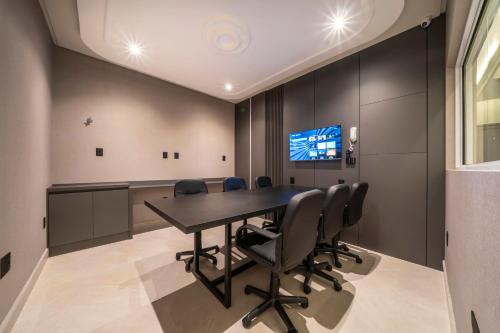 a conference room with a table and chairs at Elegance - Piscina Aquecida - Apartamento para 4 pessoas em Bombinhas in Bombinhas