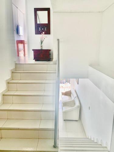 a stairway with white steps and a vase of flowers at Apto 401 Edificio El Karey in Rodadero