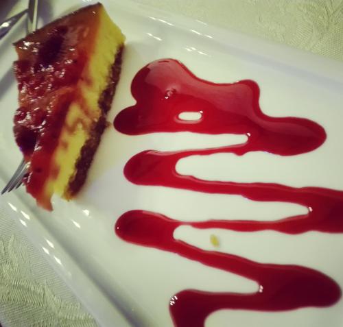 a piece of cake on a white plate with red sauce at Locanda San Giorgio in Termoli