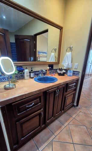 a bathroom with a sink and a large mirror at Private bedroom in gorgeous shared Versailles house with heated and cooled pool in Puerto Vallarta