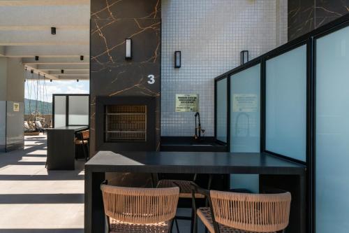 a dining room with a black table and chairs at Elegance - Piscina Aquecida - Apartamento para 4 pessoas em Bombinhas in Bombinhas