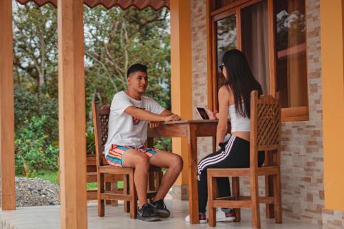 a man and a woman sitting at a table on a porch at Eco Arazzá in Mera