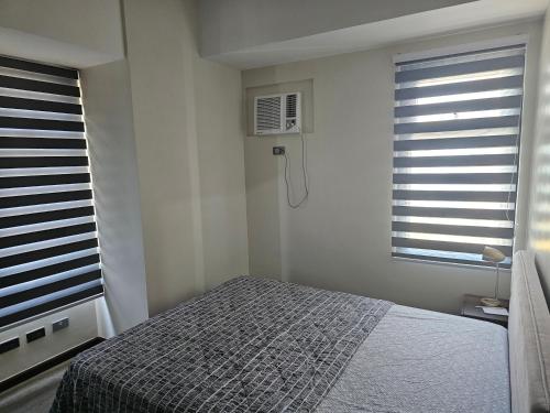 a bedroom with a bed and a window at Galleria Residences Tower in Cebu City
