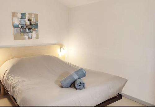 un lit blanc avec un animal farci bleu dans l'établissement Le Futuronid, à Chasseneuil-du-Poitou