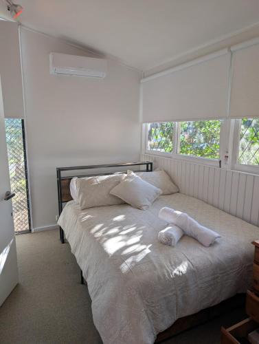 a bedroom with a bed with two towels on it at Leafy 3-Bedroom Escape to Nature-Air Conditioned with Smart Entry in Ferny Hills