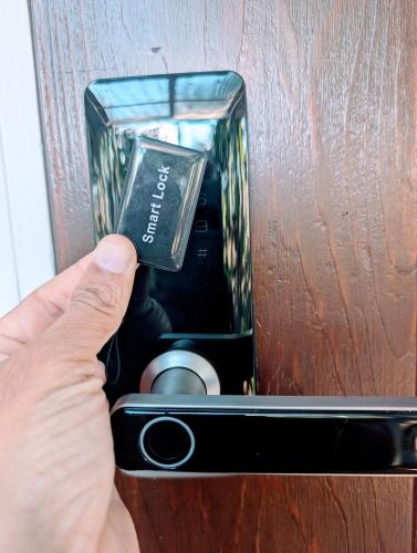 a hand is holding a box in a door at Leafy 3-Bedroom Escape to Nature-Air Conditioned with Smart Entry in Ferny Hills