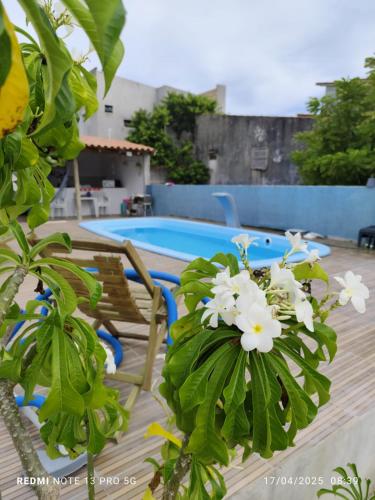 una planta con flores blancas junto a una piscina en Pousada Casa BiGui, en Santa Cruz Cabrália