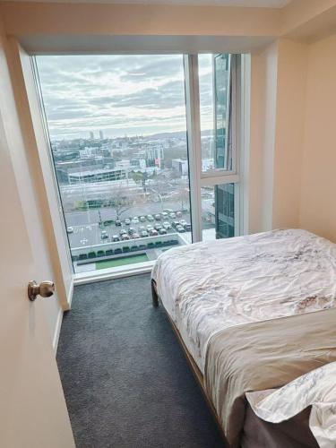 a room with a bed and a large window at Imperial Garden2 in Auckland