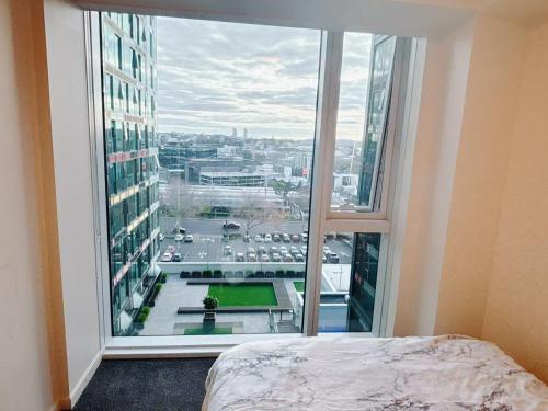 a bedroom with a large window with a view of a city at Imperial Garden2 in Auckland