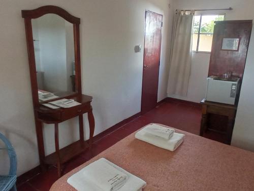 ein Badezimmer mit Spiegel und einem Tisch mit zwei Handtüchern in der Unterkunft Estancia Santa María de las Casas Viejas in Mina Clavero