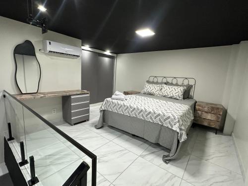 a bedroom with a bed and a mirror in it at Loft lindo e aconchegante! in Toritama