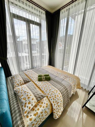 a bed in a room with large windows at Villa Kandara Batu in Tlekung