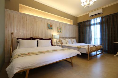 um quarto de hotel com duas camas e uma janela em Hualien Edinburgh Homestay em Hualien City