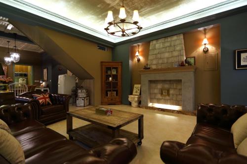 een woonkamer met lederen meubels en een open haard bij Hualien Edinburgh Homestay in Hualien