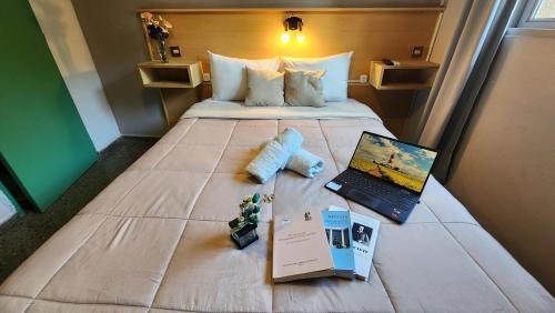 a bed in a hotel room with a laptop on it at HOTEL JUAN b JUSTO GARDEN in Mendoza
