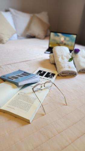 a book and glasses on top of a bed at HOTEL JUAN b JUSTO GARDEN in Mendoza