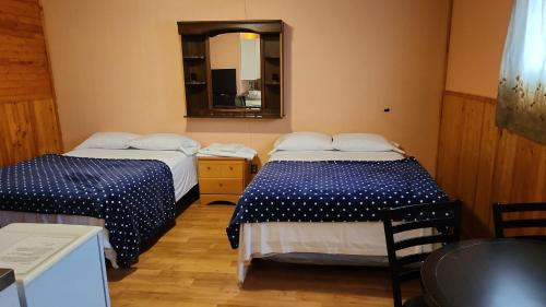 two beds in a small room with a mirror at Balgonie Motor Inn in Wolseley