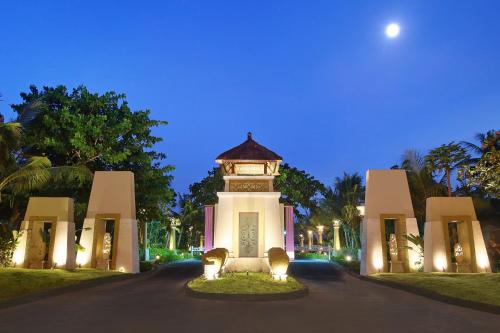 a building with a clock tower in the middle of a road at Mercure Bali Nusa Dua in Nusa Dua