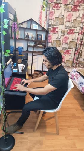 a man sitting in a chair using a laptop computer at La suite más cómoda y elegante in Mexico City