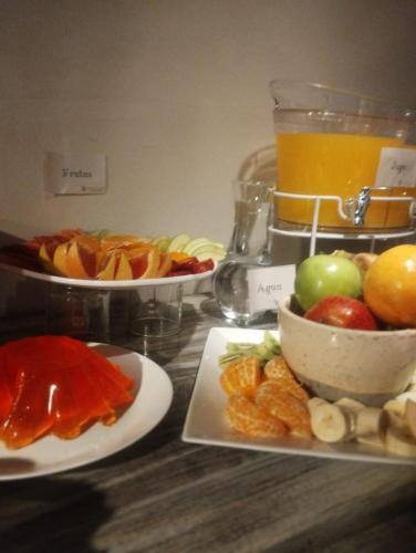 a table with plates of food and a pitcher of orange juice at HOTEL JUAN b JUSTO GARDEN in Mendoza