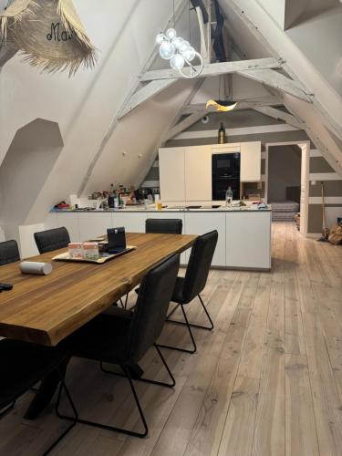 une cuisine et une salle à manger avec une table et des chaises en bois dans l'établissement Les remparts de Guerande, à Guérande