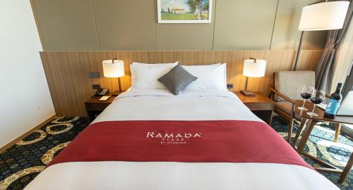 a hotel room with a bed with a red and white blanket at Ramada Plaza by Wyndham Dolsan Yeosu in Yeosu