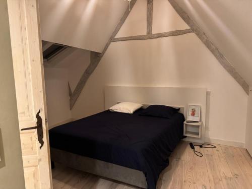 - une chambre mansardée avec un lit noir dans l'établissement Les remparts de Guerande, à Guérande