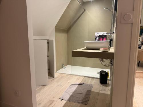 La salle de bains est pourvue d'un lavabo et d'un comptoir avec un miroir. dans l'établissement Les remparts de Guerande, à Guérande