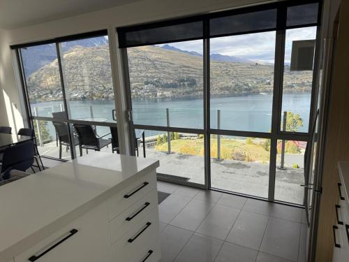 a kitchen with a view of a lake and a table at Goldrush #1 in Queenstown
