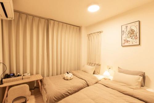 a bedroom with two beds and a teddy bear on the bed at Mars Hotel in Tokyo