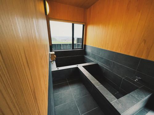 a bathroom with a bath tub and a window at Private Villa 蒼 Lala & Lino in Kyotango