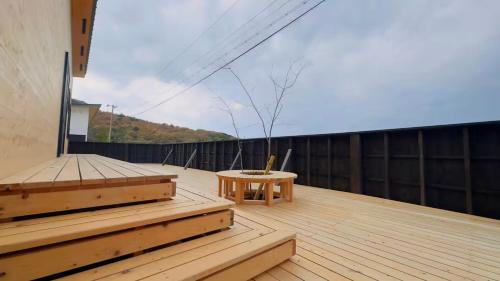 a balcony with a wooden deck with a table at Private Villa 蒼 Lala & Lino in Kyotango