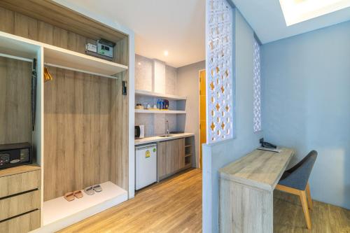 a kitchen with a table and a desk in a room at Antiya Hotel Phuket in Phuket Town