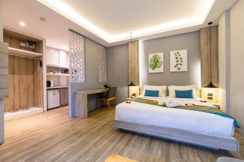 a bedroom with a large bed and a desk at Antiya Hotel Phuket in Phuket Town