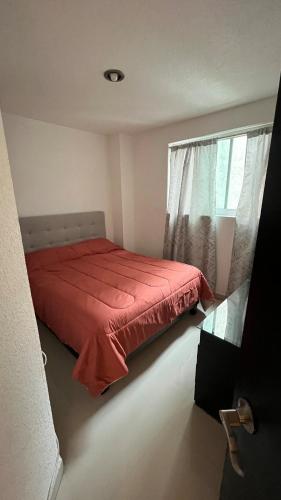 a bedroom with a red bed and a window at Bonito departamento tranquilo cerca de WTC in Mexico City
