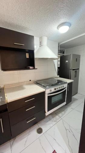 a kitchen with a stove and a refrigerator at Bonito departamento tranquilo cerca de WTC in Mexico City