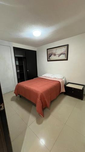 a bedroom with a bed with a red bedspread at Bonito departamento tranquilo cerca de WTC in Mexico City