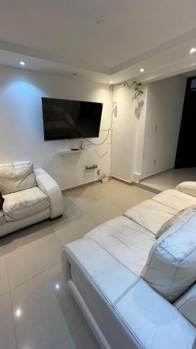 a bedroom with two beds and a flat screen tv at Bonito departamento tranquilo cerca de WTC in Mexico City