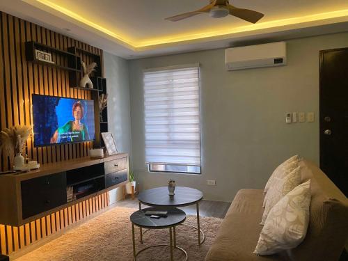 a living room with a couch and a tv at Sinsan Pension House by RH Transient Houses in Bangad