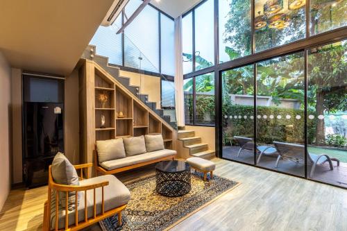 a living room with a staircase and a couch at Antiya Hotel Phuket in Phuket Town