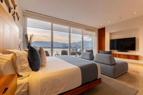 a bedroom with a large bed and a large window at Capitalia Tres Mares Beach Residences & Marina in Puerto Vallarta