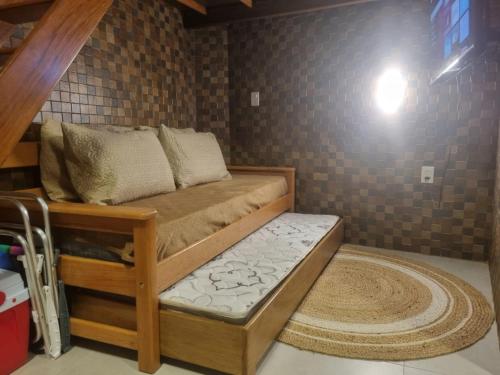 a bed in a room with a brick wall at 09 Kitnet próximo da praia com ar-condicionado in Maceió