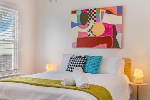 a bedroom with a bed with a painting on the wall at Tara House, Bendigo in Bendigo