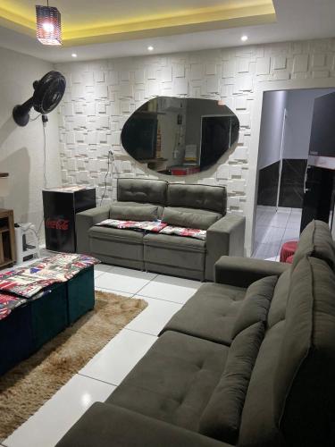 a living room with a couch and a mirror at Hotel e Pousada REQUINTTE in Parnaíba