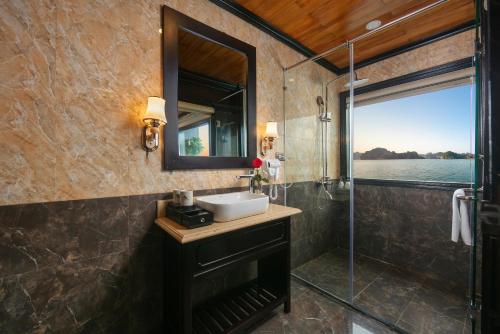 Un baño con lavabo, espejo y ducha. en Star Boutique Cruise, en Ha Long