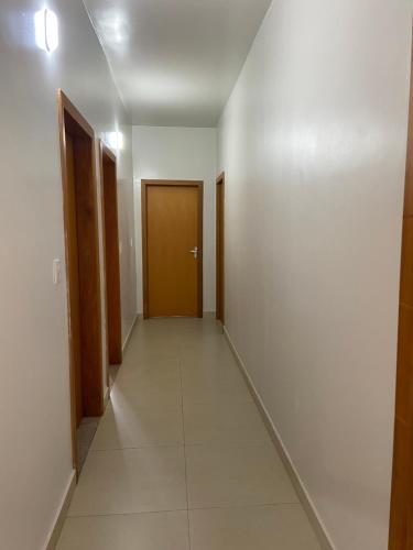 an empty hallway with a brown door and a hallwayngth at Pousada Acessus - Proximo da UniEvangelica e Hospital Anima in Anápolis