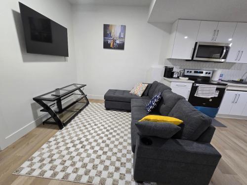 a living room with a couch and a kitchen at Amazing 2-bedroom house with WiFi in Edmonton in Edmonton