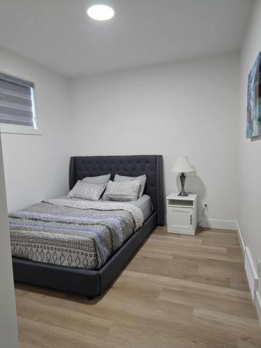 a bed in a bedroom with a black bed frame at Amazing 2-bedroom house with WiFi in Edmonton in Edmonton